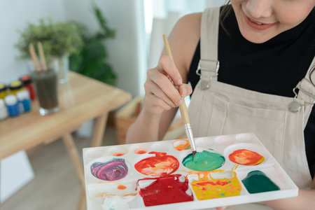 Professional female artist girl use paintbrush in abstract art for create masterpiece. painter paint with watercolors or oil in studio house. beautiful woman enjoy painting as hobby. work recreationの写真素材