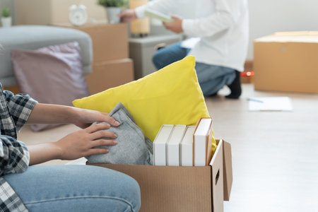 Moving house, relocation. Couple help set and move forniture for new apartment, inside the room was...