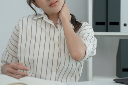 office syndromes, woman massaging neck pain due to work and using a computer, digital composite of a focused spine of neck pain and shoulder pain symptoms , injuries, health care, medical, myositisの写真素材