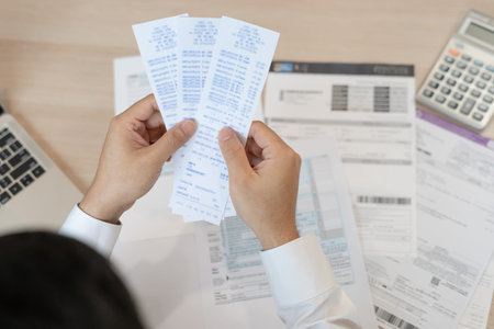 Stressed and headache man with large bills or invoices no money to pay to expenses and credit card...
