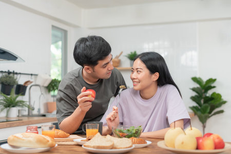 Asian couple smile and happy looking each other's eyes, cuddling, warm hugs, teenager's first love, married couple, warm family. Husband and wife in love so fun in new years eve or valentine dayの写真素材