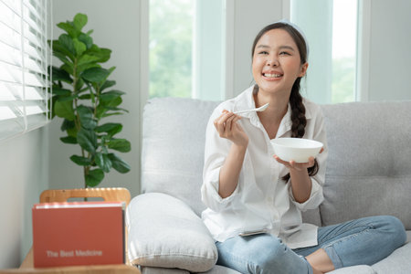 healthy food. Beautiful female girl enjoy eat yogurt, granola, fresh fruits on breakfast health in house. Happy young woman smile on morning good emotion. dieting, detox, diet, clean eat, vegetarianの写真素材
