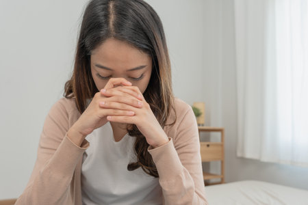 Depression and mental illness. Asian woman disappointed, sad after receiving bad news. Stressed girl confused with unhappy problems, arguing with boyfriend, cry and worry about unexpected pregnancy.の写真素材