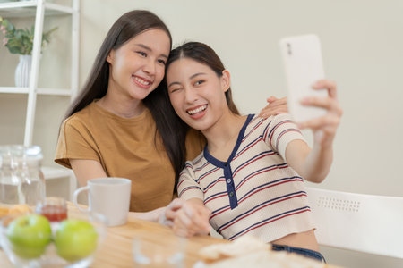 LGBT group. Good looking lesbian couples smile use tablet at home on holiday. Asian young couple hug each other happily, lover in love, bisexualities, homosexuality, liberty, expression, happy lifeの写真素材