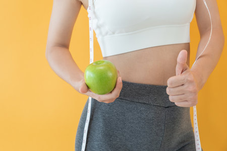 slim body asian women choose healthy foods, dieting female choose green apple for diet. Good healthy food. weight lose, balance, control, reduce fat, low calories, routines, exercise, body shape.の写真素材