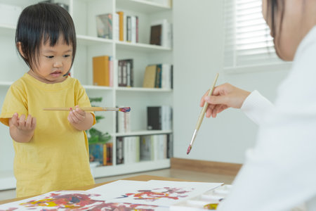 Happy Asia mother playing learning paint for little girl. Funny family is happy and excited in the house. Mother and daughter  having fun spending time together. Holiday, Activityの写真素材