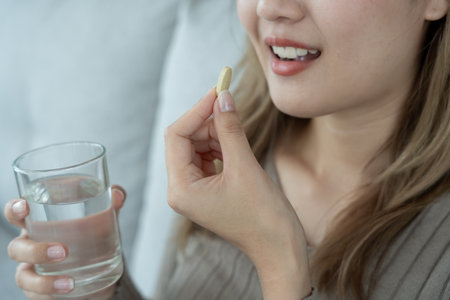 girl holding medicine and take medicine, pain, cure disease, sterilize, take vitamin, sedative, health care, Dietary supplement, medicine for medical treatment, tonic, daily dosage of medicationの写真素材