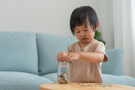 Save money. children putting coin for saving. wealth, Finance, insurance, investment, education, future, plan life, learn, banking, family, health, health and accident insurance.の写真素材