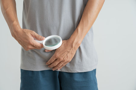 Man hold hand in front of private parts feeling discomfort from disease and inflammation. Venereal, testicular cancer. bladder problems, erectile dysfunction, premature ejaculation, prostate cancerの写真素材