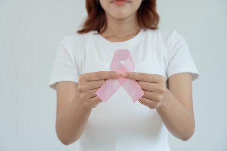 Woman hold pink ribbon breast cancer awareness. Female health check consciousness. international Women Day and World Cancer Day. sign cancer, Symbolic, health care, support patients, timely diagnosisの写真素材