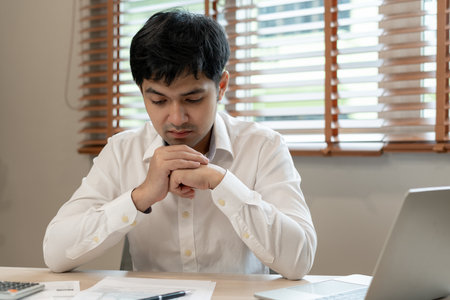 Stressed and headache asian man with large bills or invoices no money to pay to expenses and credit card debt. shortage, Financial problems, mortgage, loan, bankruptcy, bankrupt, poor, empty walletの写真素材