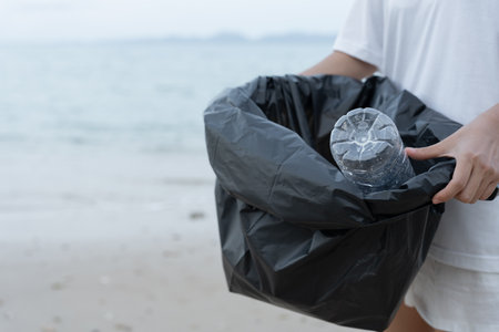 Save water. Volunteer pick up trash garbage at the beach and plastic bottles are difficult decompose prevent harm aquatic life. Earth, Environment, Greening planet, reduce global warming, Save worldの写真素材