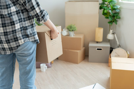 Moving house, relocation. Woman hold carton box contain equipment for new condominium, inside the...