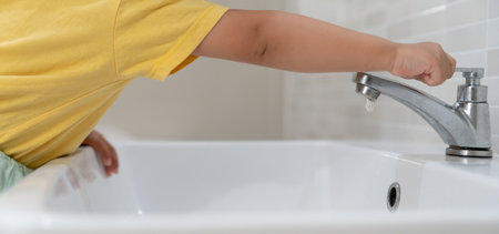 Save water. Little kid keeps turning off the running water in the bathroom to protect environment. Greening planet, reduce global warming, Save world, life, future, risk energy, crisis , water day.の写真素材