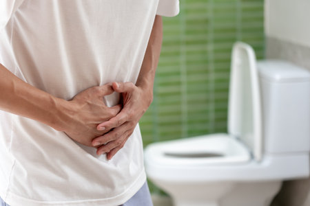 Constipation and diarrhea in bathroom. Hurt man touch belly  stomach ache painful. colon inflammation problem, toxic food, abdominal pain, abdomen, constipated in toilet, stomachache, Hygieneの写真素材