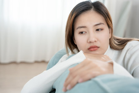 Depression and mental illness. Asian woman disappointed, sad after receiving bad news. Stressed girl confused with unhappy problems, arguing with boyfriend, cry and worry about unexpected pregnancy.の写真素材