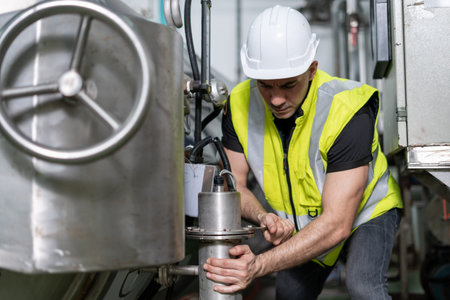 Engineers or utility staff wearing safety helmet fix the machines in the production line. Utility...