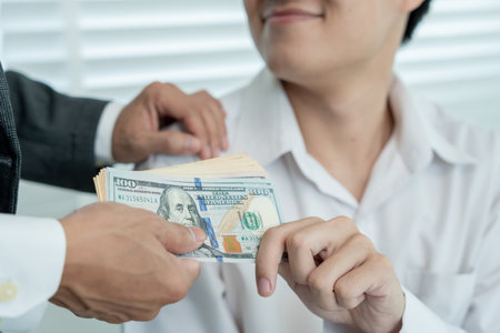 Businessmen receive salary or bonuses from management or Boss. Company give rewards to encourage work. Smiling businessman enjoying a reward at the desk in the office.の写真素材
