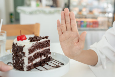 slim female body confuse chocolate cake. Woman in restaurant achieves weight loss goal for healthy...