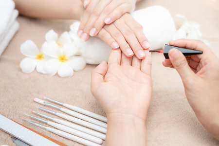 Woman receive care service by professional Beautician Manicure at spa centre. Nail beauty salon use nail file for Glazing treatment. manicurist make nail customer to beautiful. body care spa treatmentの写真素材