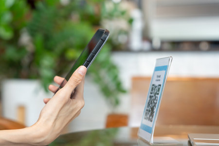 Woman use smartphone to scan QR code to pay in cafe restaurant with a digital payment without cash. Choose menu and order accumulate discount. E wallet, technology, pay online, credit card, bank app.の写真素材