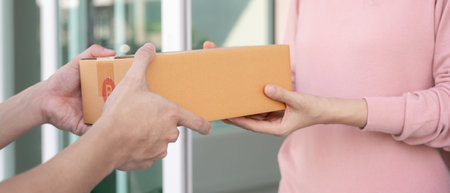 woman receives boxes parcel from courier in front house. Delivery man send deliver express. online...