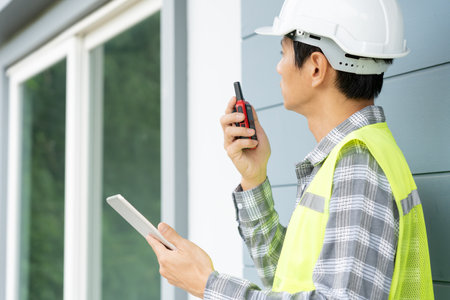 inspector or engineer is inspecting construction and quality assurance new house using a tablet. Engineers or architects or contactor work to build the house before handing it over to the homeownerの写真素材
