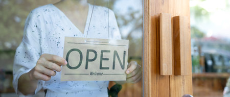 Business woman owner open on the first day of business. guarantees safety, cleanliness, open the coffee shop. open for New normal. Small business, welcome, restaurant, home madeの写真素材