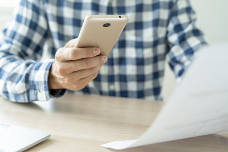 business man use phone to scan barcode or QR codes to pay credit card bill after receiving document invoice online. payment, receive, paying electricity, digital payments without money, technologyの写真素材