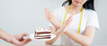 Beauty slim female body confuse chocolate cake. Woman in restaurant achieves weight loss goal for healthy life, crazy about thinness, thin waist, nutritionist. Diet, body shape.の写真素材