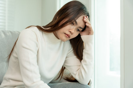 Depression and mental illness. Asian woman disappointed, sad after receiving bad news. Stressed girl confused with unhappy problems, arguing with boyfriend, cry and worry about unexpected pregnancy.の写真素材