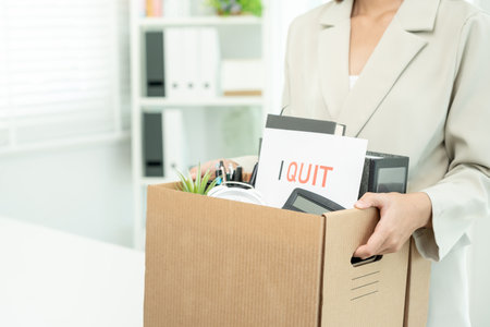 resignation, leave, quit, Stressful businesswomen will resign from the company. Female staff is lifting a brown paper box that holds personal items. , job placement and vacancies, resignation letterの写真素材
