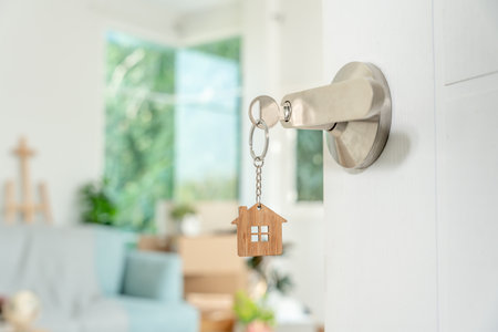 Moving house, relocation. The key was inserted into the door of the new house, inside the room was a cardboard box containing personal belongings and furniture. move in the apartment or condominiumの写真素材