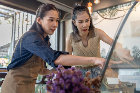 Asia woman owner happy and smile receive order from customer. guarantees safety, cleanliness, open the coffee shop. open for New normal. Small business, welcome, restaurant, home made,の写真素材