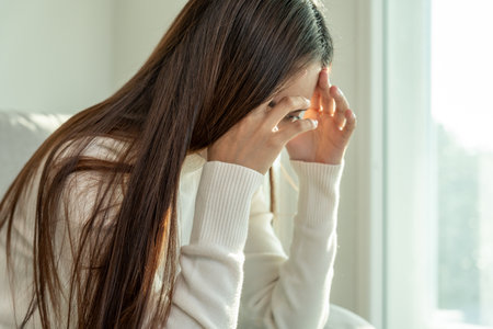Depression and mental illness. Asian woman disappointed, sad after receiving bad news. Stressed girl confused with unhappy problems, arguing with boyfriend, cry and worry about unexpected pregnancy.の写真素材
