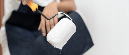 painter man, brush in hand for products to restore and paint the wall, indoor the building site of a...