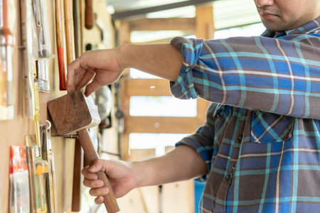 man owner a small furniture business is preparing equipment for work. carpenter male is adjust wood...