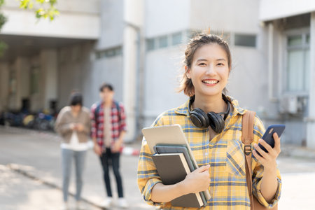Portrait beautiful Asian woman student. Smile girl happy study. read book in college campus. young female on international Asia University. Education, study, school, learning, exam, continue educationの写真素材