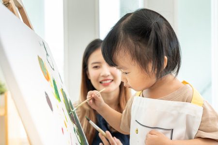 Happy Asia mother playing learning paint for little girl. Funny family is happy and excited in the house. Mother and daughter  having fun spending time together. Holiday, Activityの写真素材