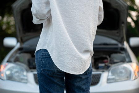 breakdown, broken car, repair. Woman uses mobile phone check insurance premiums through application...