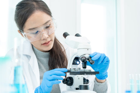 Scientist analyze biochemical samples in advanced scientific laboratory. Medical professional use microscope look microbiological developmental of viral. Biotechnology research in science lab.の写真素材