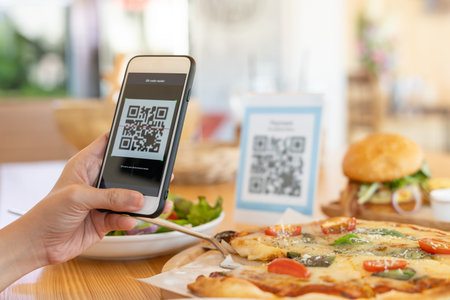 Woman use smartphone to scan QR code to pay in cafe restaurant with a digital payment without cash....