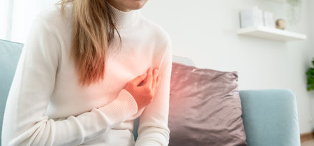hand hold chest with heart attack symptoms, asian woman have chest pain caused by heart disease, leak, dilatation, enlarged coronary heart, press on the chest with a painful expressionの写真素材