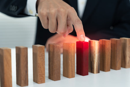 insurance with hands protect domino. Businessman hands stop dominoes falling in house crisis. business risk control and planning and strategies to run prevent insurance businesses.の写真素材