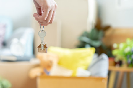 Moving house, relocation. Woman hold key house keychain in new apartment. move in new home. Buy or rent real estate. flat tenancy, leasehold property, new landlord, dwelling, loan, mortgage.の写真素材