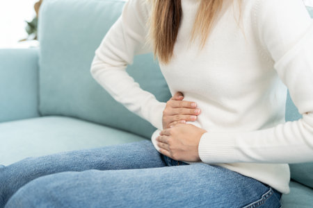 stomach ache. Asian women have abdominal pain, indigestion, gastritis, menstrual cramps, flatulence, diarrhea, distention, colon cancer, belly inflammation problem, suffer food poisoning, abdomenの写真素材
