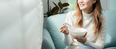 Asian Woman having delicious healthy breakfast at home on morning. Health care female eats yogurt...