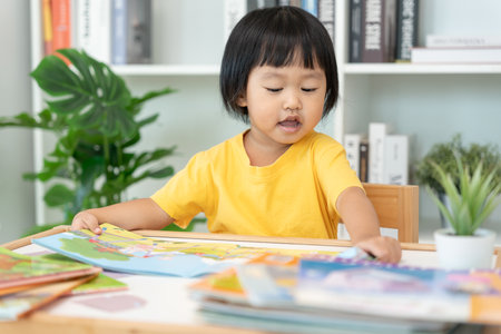 Happy Asian children relax read book at home. daughter and reading a story. learn development, childcare, laughing, education, storytelling, practice, imagine, reduce addiction mobile phoneの写真素材