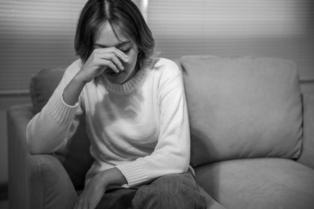 Monochrome picture, Depression and mental illness. Asian woman disappointed, sad after receiving bad news. Stressed girl confused with unhappy problems, cry and worry about unexpected pregnancy.の写真素材