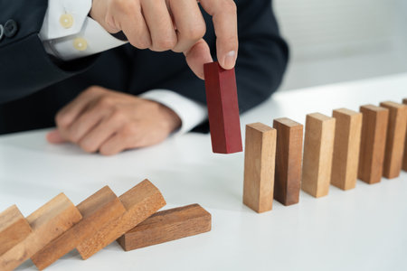 insurance with hands protect domino. Businessman hands stop dominoes falling in business crisis....